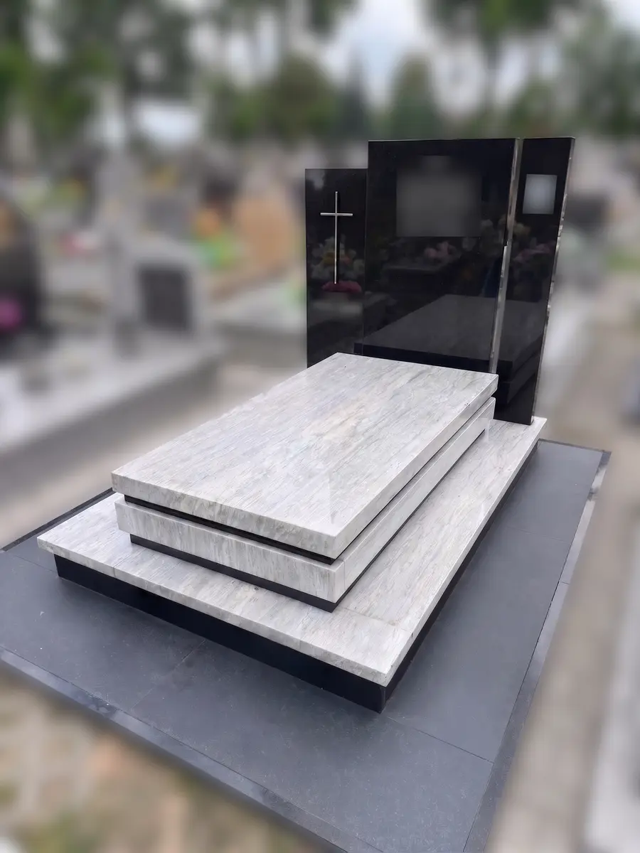 Nagrobek z jasnego granitu z warstwową płytą i czarną stelą z krzyżem